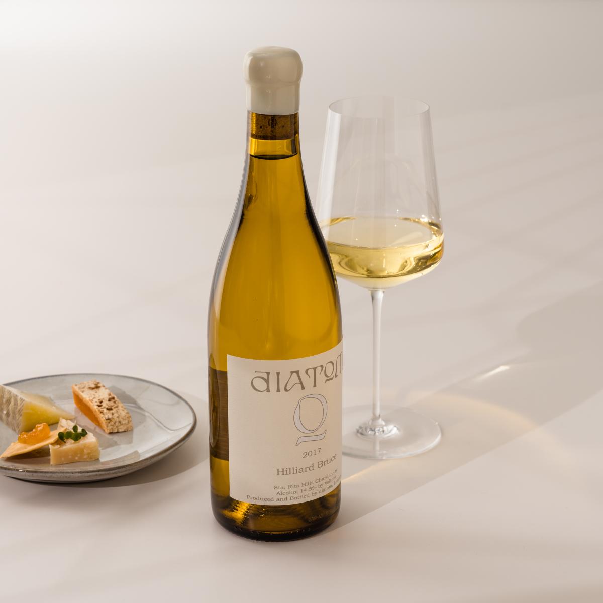 White wine bottle, wine glass and cheese 