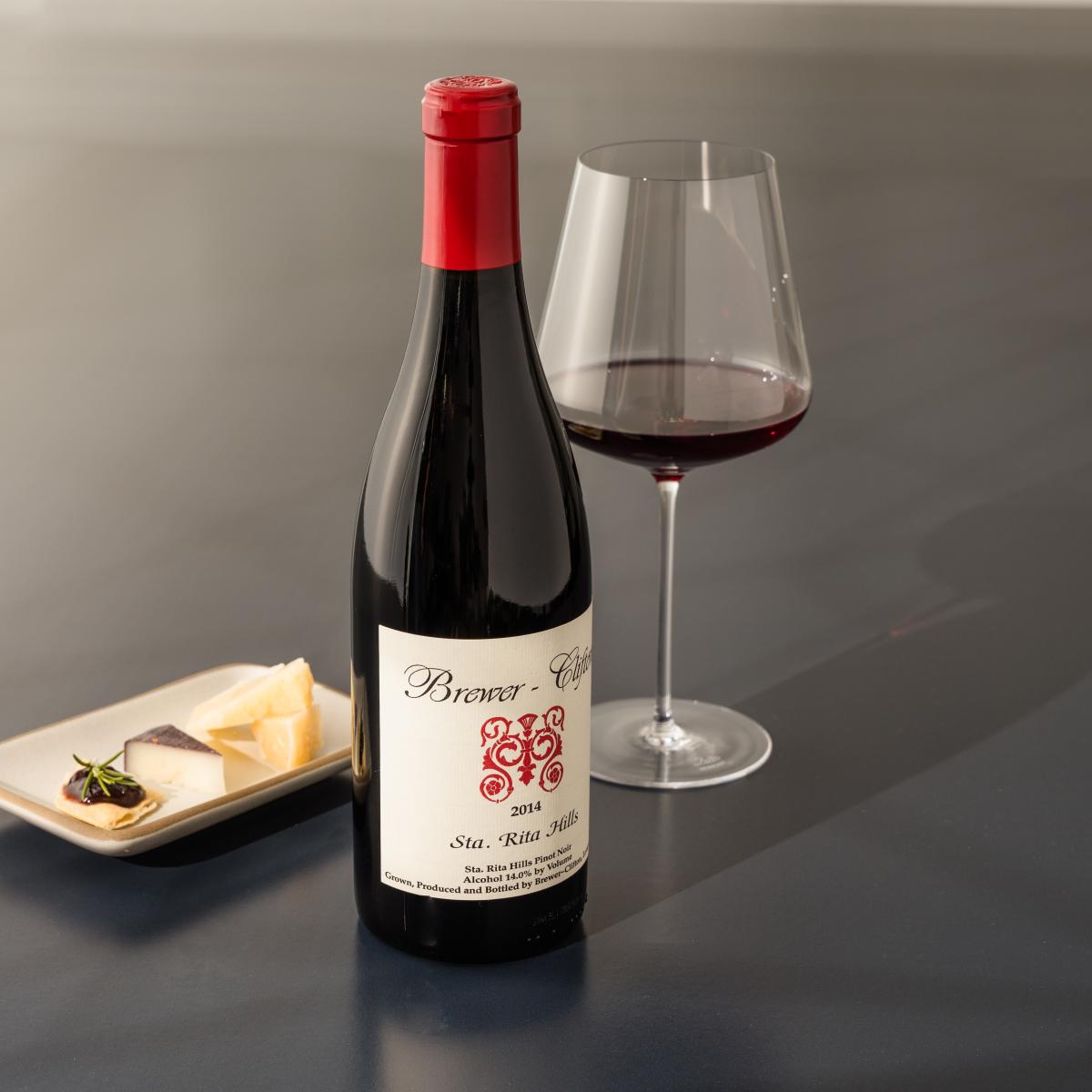 Pinot Noir red wine bottle, wine glass and cheese